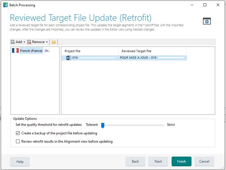 Trados Studio Reviewed Target File Update (Retrofit) window showing a project file for French (France) with a reviewed target file named POUR MISE A JOUR - 019. Update options include a quality threshold set to Tolerant and checkboxes for creating a backup and reviewing retrofit results in Alignment view.
