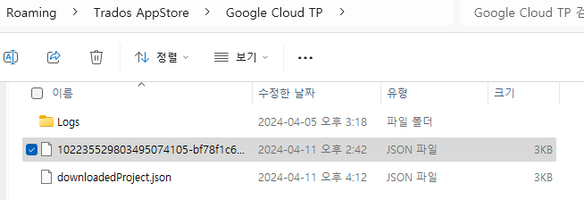 File explorer window showing Trados AppStore, Google Cloud TP folder with a Logs folder, a JSON file named xxxxxxxxxxxxxxxxxx-b7f8f16c..., and a downloadedProject.json file.