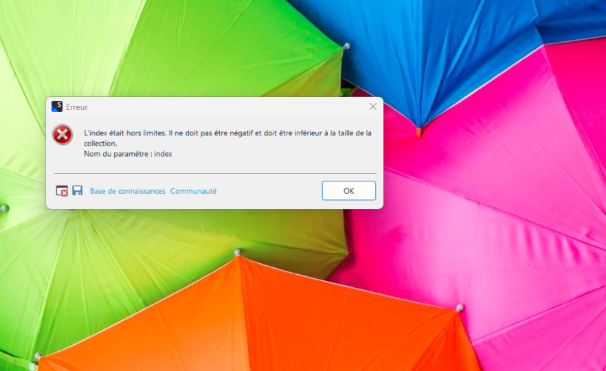 Error message on Trados Studio software over a background of colorful umbrellas. The message indicates an issue with an index being out of limits and not being allowed to be negative or greater than the size of the collection.