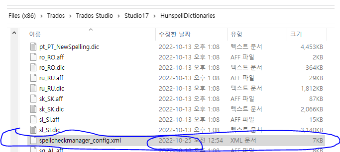 File explorer showing the 'spellcheckmanager_config.xml' file highlighted in the Trados Studio HunspellDictionaries directory.
