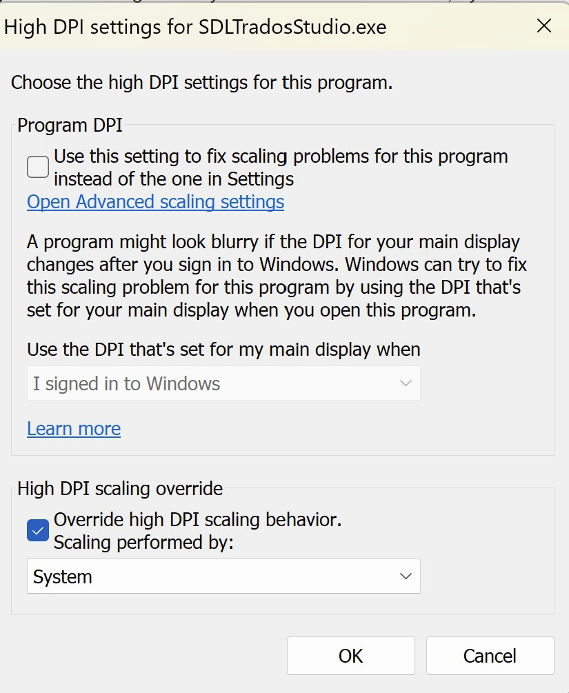 Screenshot of High DPI settings for SDLTradosStudio.exe, with 'Override high DPI scaling behavior' checked and 'Scaling performed by: System' selected.