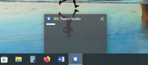 Screenshot showing Trados Studio startup screen stuck without loading progress on a desktop with taskbar icons visible.