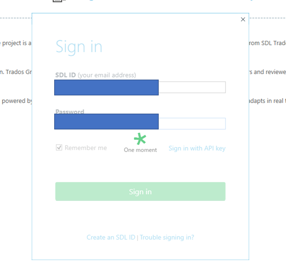 Trados Studio sign-in window with fields for SDL ID and Password filled out, a 'Remember me' checkbox, and a 'Sign in' button. A loading symbol with text 'One moment' is displayed, indicating a waiting process.