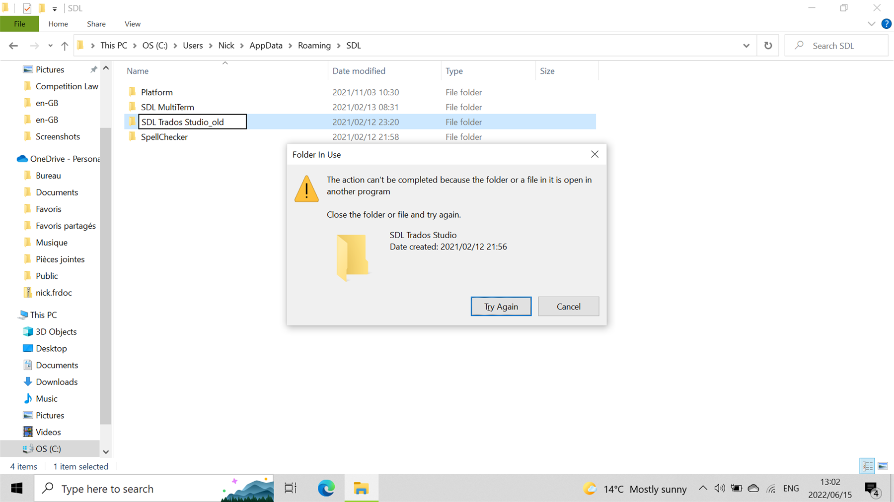 Error message window overlaying a file explorer showing SDL folders. Message reads 'The action can't be completed because the folder or a file in it is open in another program'.