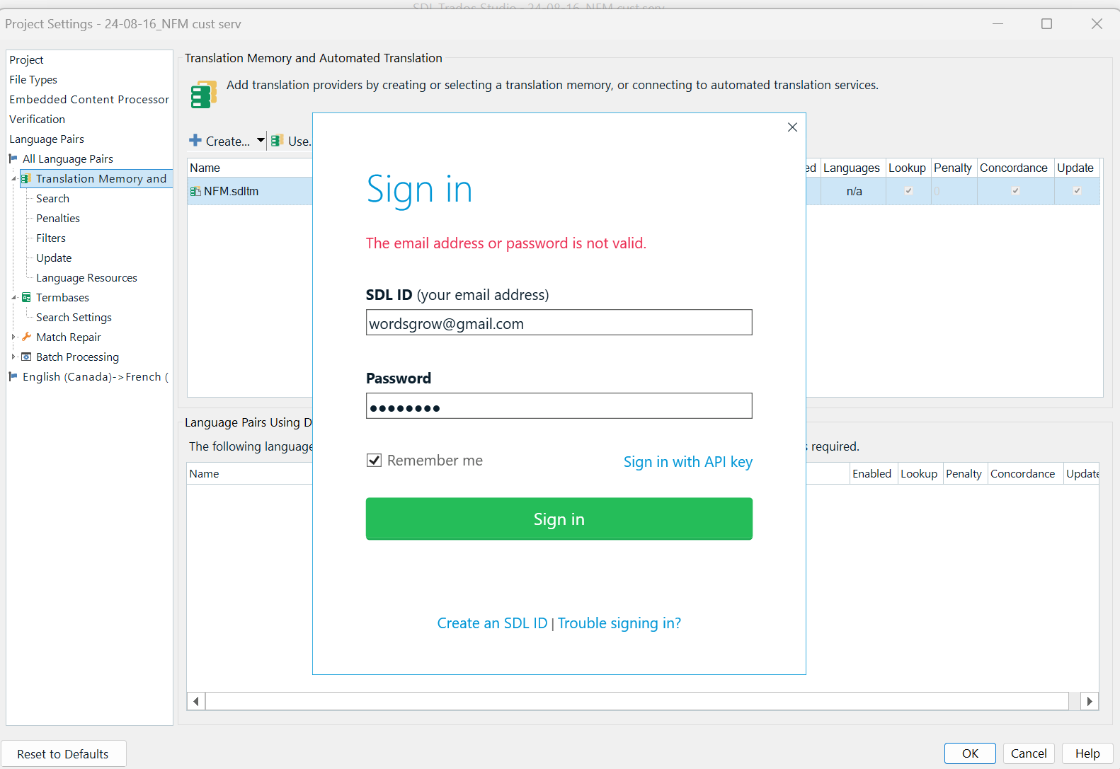 Screenshot of an SDL Trados Studio login window with an error message stating 'The email address or password is not valid.' The user's email 'wordsgrow@gmail.com' is entered in the SDL ID field, and the password field is filled with obscured characters. Options to 'Remember me,' 'Sign in with API key,' and links to 'Create an SDL ID' or 'Trouble signing in?' are also visible.