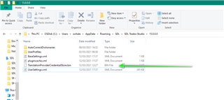 Screenshot of a file explorer window with a list of files and folders. A green arrow points to the 'UserSettings.xml' file indicating its location for Trados Studio 2019.