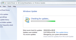 Windows Update screen showing 'Checking for updates...' with the most recent check and updates installed dates visible.