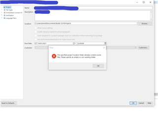 Trados Studio project settings window with an error message popup saying 'The specified project location folder already contains some files. Please specify an empty or new folder.'