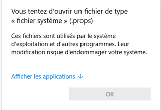 Warning message in French stating that the user is trying to open a system file (.props) and that modifying it could damage the system, with an option to show applications.