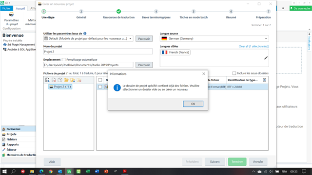 Trados Studio error message: 'The specified project folder already contains files. Please select an empty folder or create a new one.' with an 'OK' button.